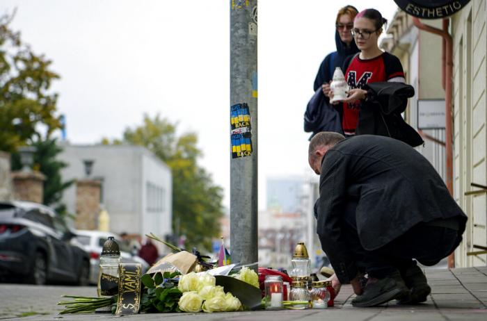 People lay flowers and light candles at the scene of Wednesday's attack on Zamocka Street in Bratislava, Slovakia, Thursday, Oct. 13, 2022. 