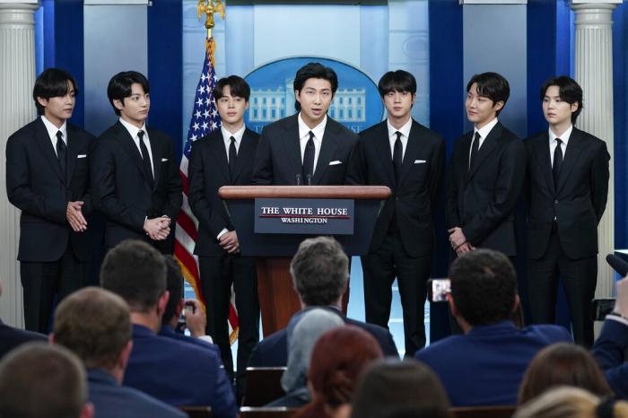 RM, center, accompanied by other K-pop supergroup BTS members from left, V, Jungkook, Jimin, Jin, J-Hope, and Suga speaks during the daily briefing at the White House in Washington, Tuesday, May 31, 2022.