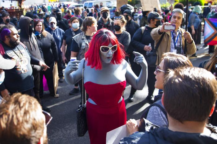 Drag performer Emma Lavin, center, attempts to find middle ground with protesters against a drag queen story time outside Old Nick's Pub in Eugene, Ore., Sunday, Oct. 23, 2022.