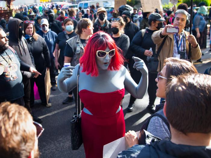Drag performer Emma Lavin, center, attempts to find middle ground with protesters against a drag queen story time outside Old Nick's Pub in Eugene, Ore., Sunday, Oct. 23, 2022.
