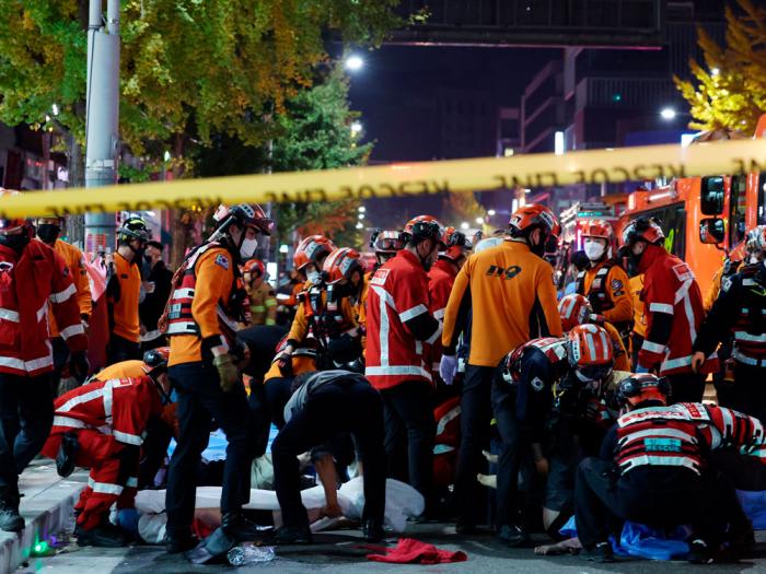 Rescue workers and firefighters work on the scene of a crushing accident in Seoul, South Korea, Saturday, Oct. 29, 2022. 