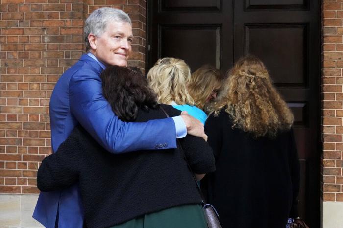 Steve Johnson, brother of U.S. murder victim Scott Johnson, hugs his wife Rosemarie as they arrive at the Supreme Court in Sydney, May 2, 2022, for a sentencing hearing in the murder of Scott.