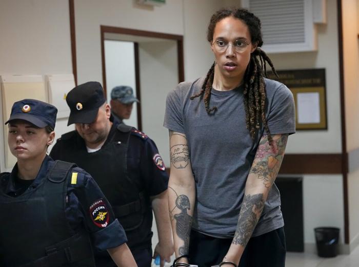WNBA star and two-time Olympic gold medalist Brittney Griner is escorted from a courtroom after a hearing in Khimki just outside Moscow, Russia.