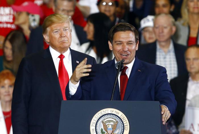 Then-President Donald Trump stands behind gubernatorial candidate Ron DeSantis at a rally in Pensacola, Fla.