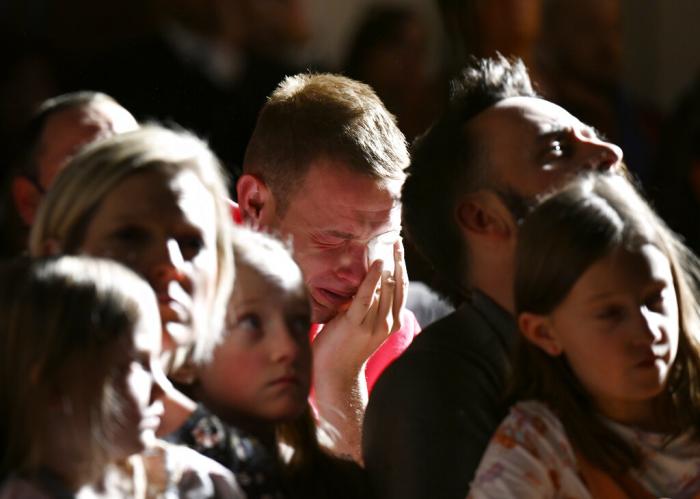 R.J. Lewis, center, attends a vigil at All Souls Unitarian Church with others, Sunday, Nov. 20, 2022, in Colorado Springs, Colo., following a fatal shooting at gay nightclub Club Q late the night before. 