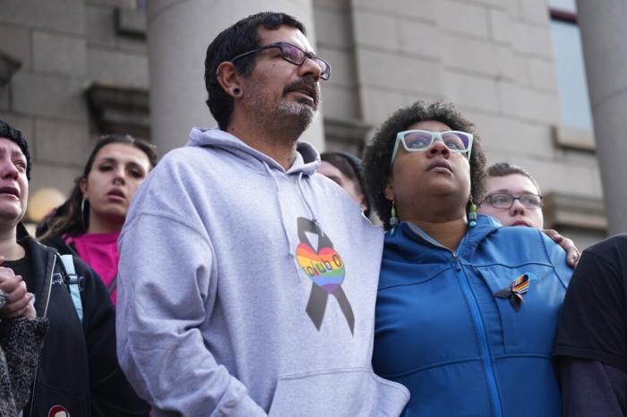 Juan Chavez, left, hugs Jennifer Horn as they join other Club Q supporters in standing on the steps beneath a 25-foot historic pride flag displayed on the exterior of city hall to mark the weekend mass shooting at a gay nightclub Wednesday, Nov. 23, 2022, in Colorado Springs, Colo. 