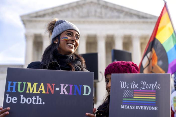 Pro-gay rights supporter Amrita Bhowmick and her daughter Maya, 10, stand outside the Supreme Court in Washington, Monday, Dec. 5, 2022.