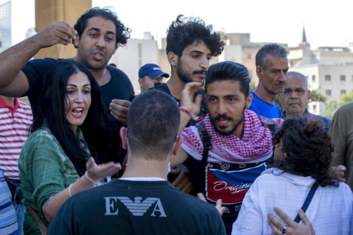 A group of activists from the LGBTQ community, background, argue with opponents of their rally in which they are calling on the government for more rights in the country gripped by economic and financial crisis, during ongoing protests in Beirut, Lebanon, Saturday, June 27, 2020.