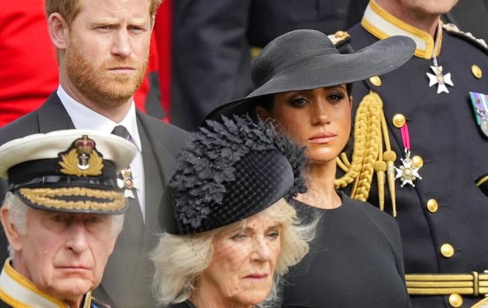 Britain's King Charles III, from bottom left, Camilla, the Queen Consort, Prince Harry and Meghan, Duchess of Sussex watch as the coffin of Queen Elizabeth II is placed into the hearse following the state funeral service in Westminster Abbey in central London Monday Sept. 19, 2022. 