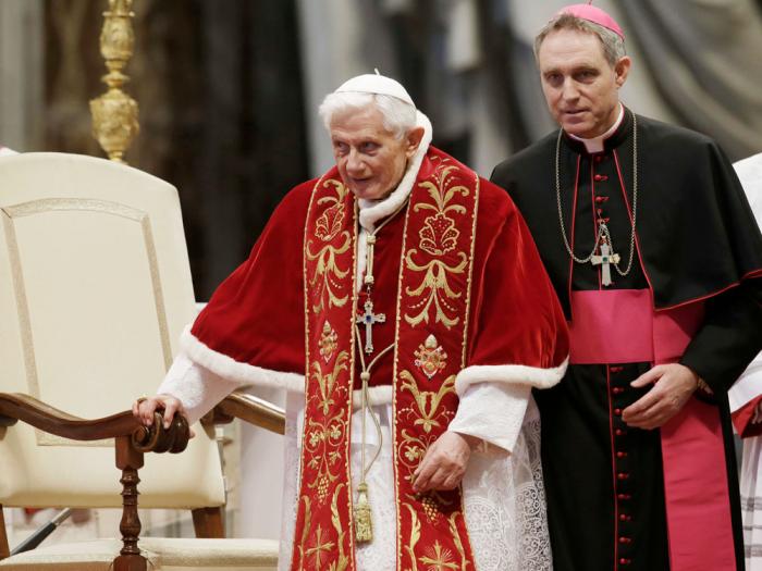 The body of late Pope Emeritus Benedict XVI laid out in state as father Georg Gaenswein stands on the right inside St. Peter's Basilica at The Vatican, Monday, Jan. 2, 2023.