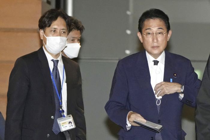 Senior aide to the prime minister Masayoshi Arai, left, walks next to Prime Minister Fumio Kishida at the Prime Minister's official residence in Tokyo, Dec. 12, 2022. 