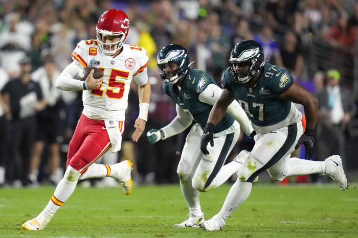 Kansas City Chiefs quarterback Patrick Mahomes (15) runs against Philadelphia Eagles defensive tackle Javon Hargrave (97) and linebacker Haason Reddick (7) during the second half of the NFL Super Bowl 57 football game, Sunday, Feb. 12, 2023, in Glendale, Ariz.
