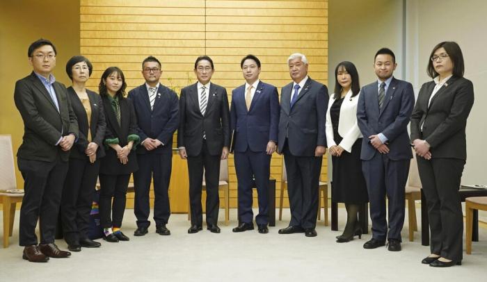 Japanese Prime Minister Fumio Kishida, center left, poses with the leaders of LGBTQ groups, as Kishida apologized to them over his former aide's discriminatory remarks, at the prime minister's office in Tokyo, Friday, Feb. 17, 2023.