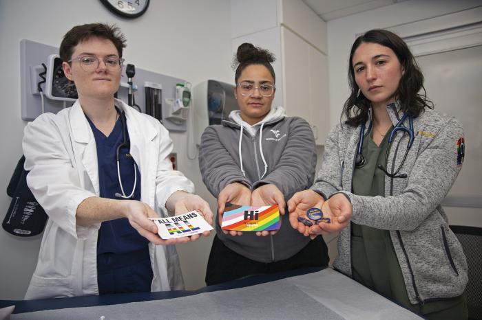 West Virginia University students El Didden, Bri Caison and Lia Farrell hold materials from the Rainbow Coats on Wednesday, March 8, 2023, in Morgantown, W.Va. 