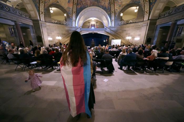 Glenda Starke wears a transgender flag as a counterprotest during a rally in favor of a ban on gender-affirming health care legislation, Monday, March 20, 2023, at the Missouri Statehouse in Jefferson City, Mo. 