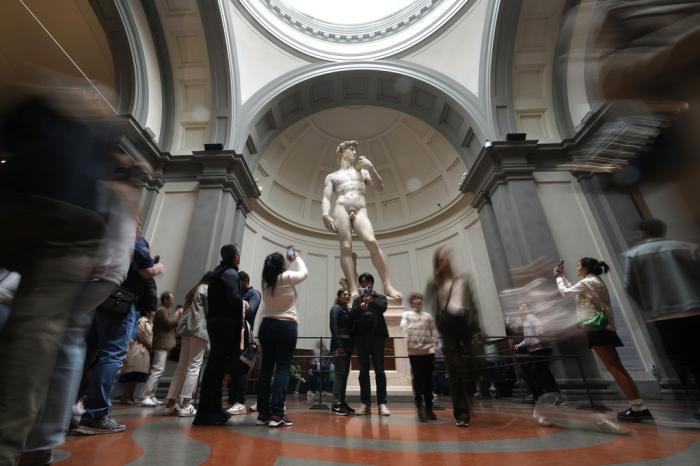 Tourists take photos in front of Michelangelo's "David statue" in the Accademia Gallery in Florence, Italy, Tuesday, March 28, 2023.