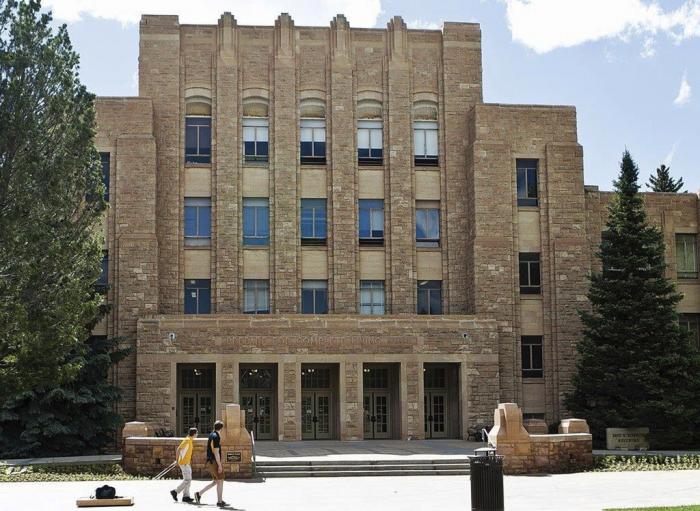 Two people walk on the University of Wyoming campus in Laramie, Wyo. 