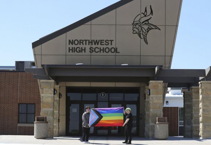 Former Viking Saga student newspaper staff members Marcus Pennell, left, and Emma Smith display a pride flag outside of Northwest High School in Grand Island, Neb., July 20, 2022