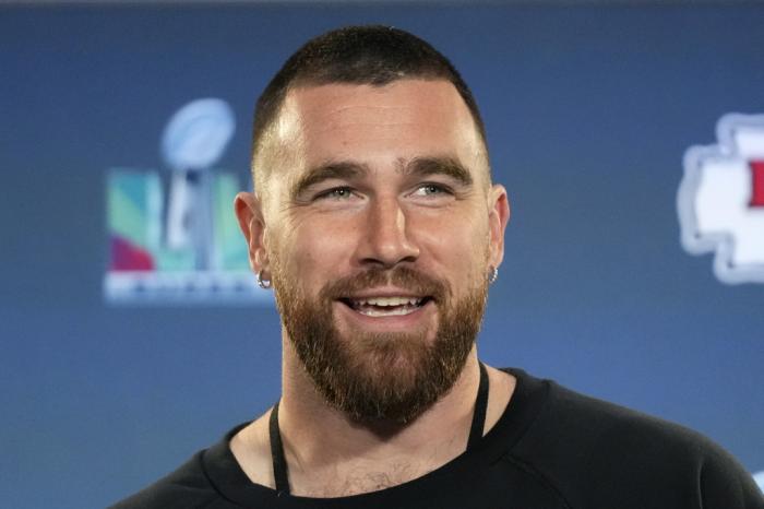 Kansas City Chiefs tight end Travis Kelce smiles as he listens to a question during an NFL football media availability in Scottsdale, Ariz., on Feb. 9, 2023. 