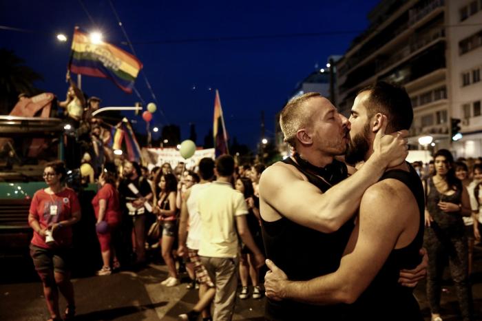 Two men kiss during an annual Gay Pride rally in Athens, Greece, Saturday, June 13, 2015.
