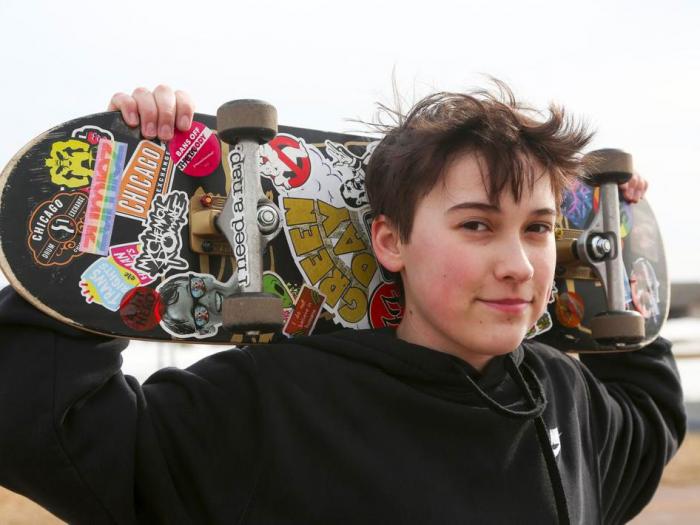 Asher Wilcox-Broekemeier, 13, poses for a portrait with his sticker-adorned skateboard, Monday, March 27, 2023, in Sioux Falls, S.D. 