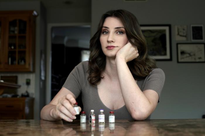 Transgender woman Stacy Cay displays some of the hormone therapy drugs she has stockpiled in fear of losing her supply, Thursday, April 20, 2023, at her home in Overland Park, Kan. 
