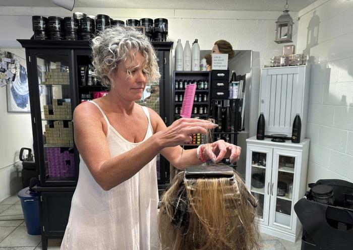 Christine Geiger cuts a customer's hair at her salon Wednesday, July 12, 2023, in Traverse City, Mich. 