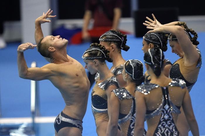 Bill May, left, leads the United States team out to compete in the team acrobatic of artistic swimming at the World Swimming Championships in Fukuoka, Japan, Saturday, July 15, 2023. 