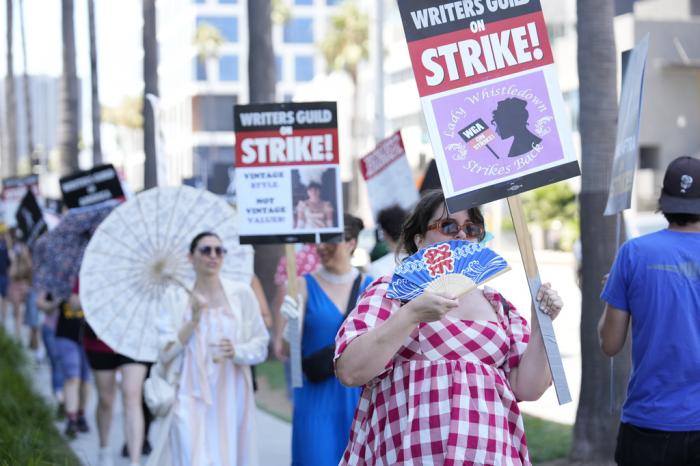 Picketers dressed as characters from "Bridgerton" carry signs outside Netflix studios on Tuesday, July 18, 2023, in Los Angeles.