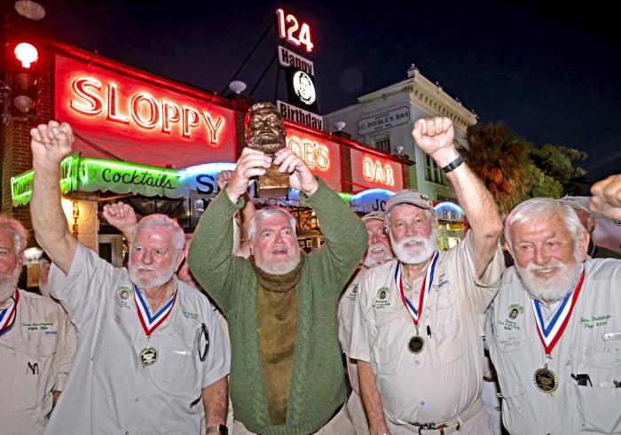 Gerrit Marshall, center, hoists his trophy after winning the Hemingway Look-Alike Contest at Sloppy Joe's Bar in Key West, Fla.