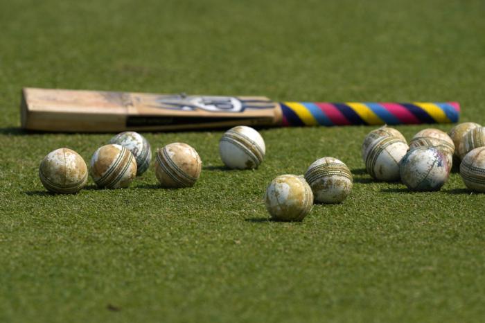 Cricket balls and a bat is seen on the ground before the start of ICC Men's Cricket World Cup match between New Zealand and South Africa in Pune, India, Wednesday, Nov.1, 2023.