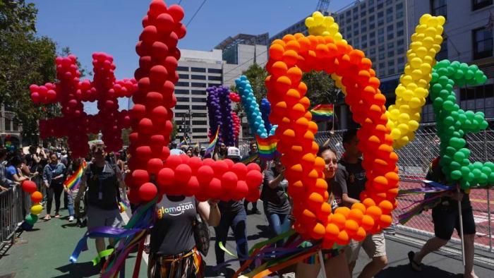 Pride Parade participants carry Love signs down Market Street in San Francisco on Sunday, June 24, 2018. (Liz Moughon/San Francisco Chronicle via AP)