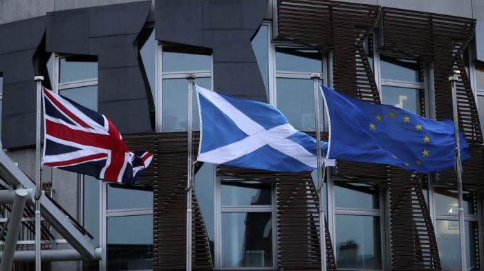 The flags of Britain, Scotland and European Union wave outside the Scottish parliament in Edinburgh, Friday, Jan. 31, 2020.