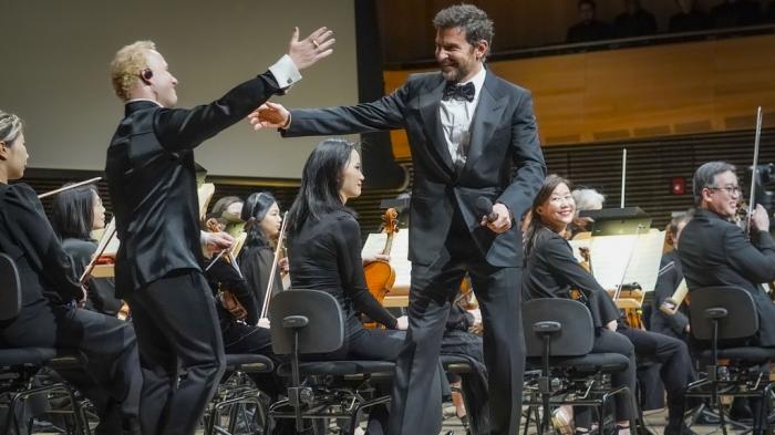 The Metropolitan Opera new music director Yannick Nézet-Séguin, left, greet actor and director Bradley Cooper, center, as he comes on stage to conduct the New York Philharmonic, Wednesday, Feb. 14, 2024, in New York. 