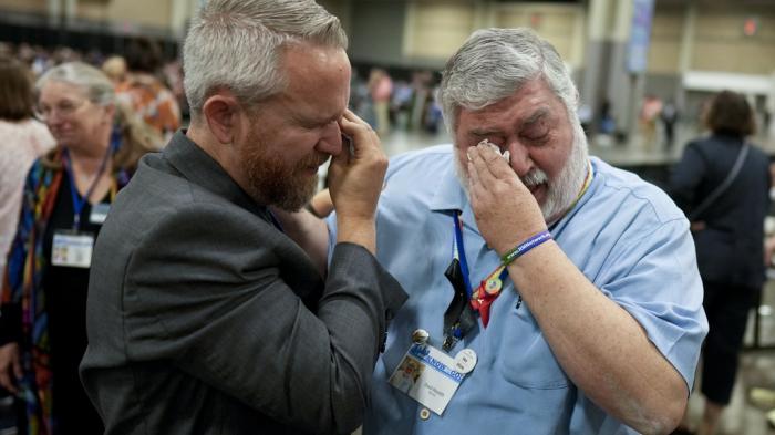 David Oliver, left, and David Meredith wipe away tears after an approval vote at the United Methodist Church General Conference Wednesday, May 1, 2024, in Charlotte, N.C. 