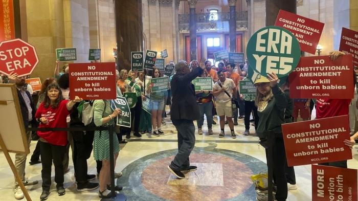 Dozens of supporters and opponents of the Minnesota Equal Rights Amendment legislation held signs — green in support, red in opposition — outside the Minnesota House chamber in the State Capitol building in St. Paul, Minn., on Monday, May 13, 2024, ahead of a crucial House floor vote on the legislation.