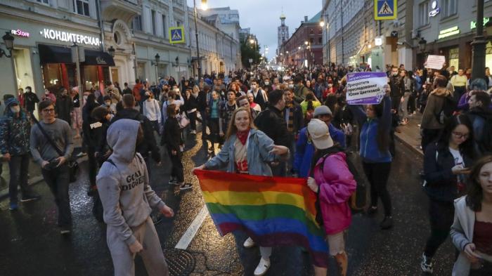 LGBT activists hold their flag at a rally to collect signatures to cancel the results of voting on amendments to the Constitution in Pushkin Square in Moscow, Russia, Wednesday, July 15, 2020. 