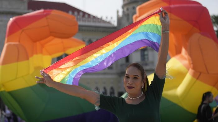 A participant holds a rainbow flag at government house in Bangkok, Thailand, Tuesday, June 18, 2024.