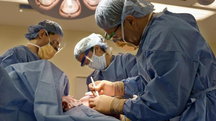 Surgeons perform a bilateral mastectomy on a transgender patient at a hospital in Boston on Friday, July 15, 2016.