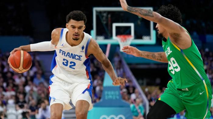 Victor Wembanyama, of France, drives on Lucas Dias, of Brazil, in a men's basketball game at the 2024 Summer Olympics, Saturday, July 27, 2024 in Villeneuve-d'Ascq, France. (AP Photo/Mark J. Terrill)