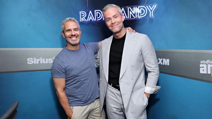 Ryan Serhant poses for a photo with host Andy Cohen (L) during a visit to SiriusXM's Andy Cohen Live at the SiriusXM Studios on July 17, 2024 in New York City