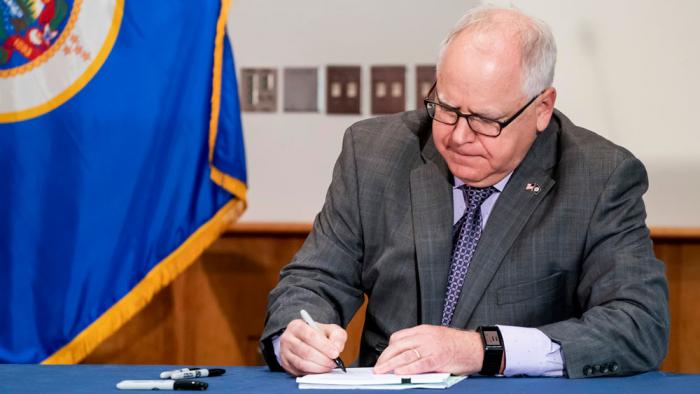 Gov. Tim Walz signs into law a sweeping package of police accountability measures in St. Paul, Minn., on July 23, 2020, including a ban on neck restraints, in the wake of George Floyd's death