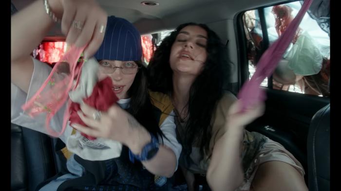 Billie Eilish, left, and Charli xcx in the "Guess" music video. 