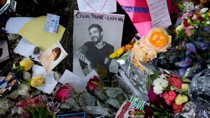 A picture of former One Direction singer Liam Payne sits surrounded by flowers and candles as fans gather outside the hotel where he was found dead after falling from a balcony in Buenos Aires, Argentina, Thursday, Oct. 17, 2024