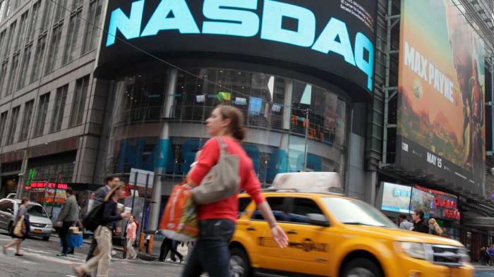 Commuters traverse New York's Times Square in front of the Nasdaq MarketSite, Wednesday, May 16, 2012