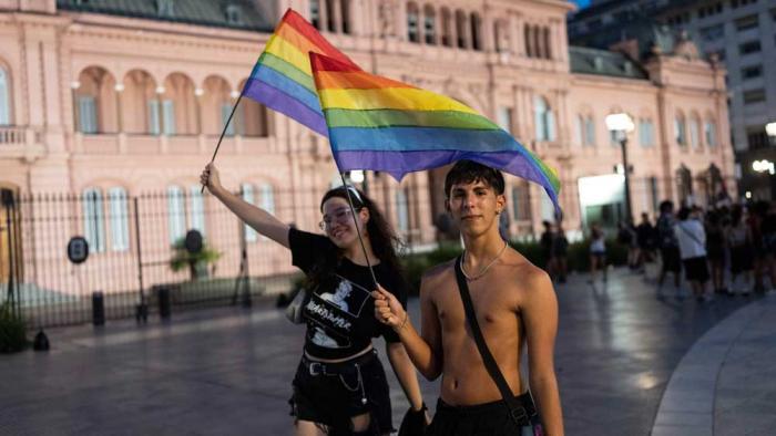 People holding rainbow-colored flags gather in Buenos Aires, Argentina, Saturday, Feb. 1, 2025, to protest President Javier Milei's speech at the World Economic Forum in Davos, during which he criticized "sick wokeism," social welfare, feminism, identity politics and the fight against climate change. (AP Photo/Rodrigo Abd)