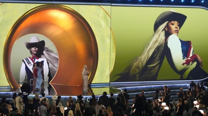 Beyonce accepts the award for best country album for "COWBOY CARTER" during the 67th annual Grammy Awards on Sunday, Feb. 2, 2025, in Los Angeles. Taylor Swift looks on from left.