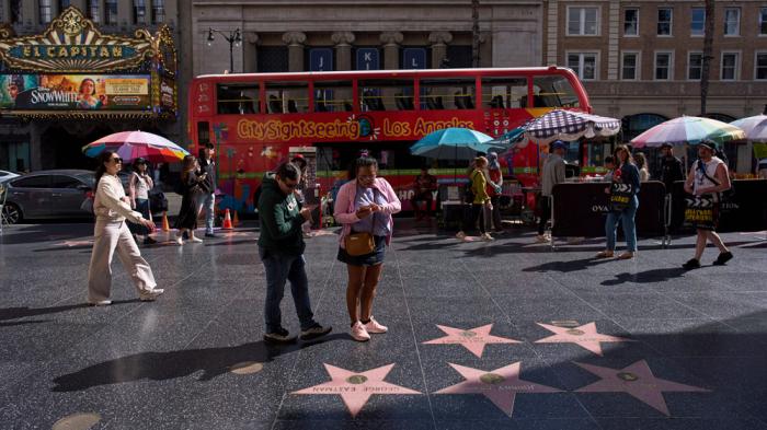 Tourists walk along the Hollywood Walk of Fame in Los Angeles, Friday, April 4, 2025