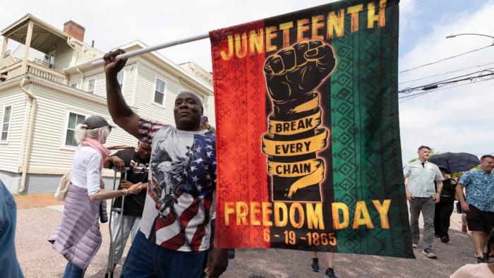 Robert Reid holds a flag during a Juneteenth celebration at the African Burying Ground Memorial Park Thursday, June 19, 2025, in Portsmouth, N.H.