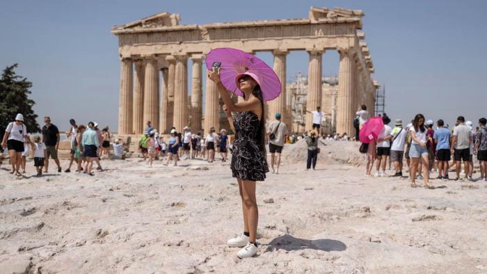 A woman takes a selfie in front of Parthenon temple atop of the ancient Acropolis hill during a heat wave in Athens, Greece, July 21, 2023